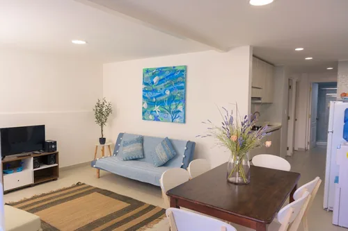 Living del Departamento 1 con televisor y sofá cama