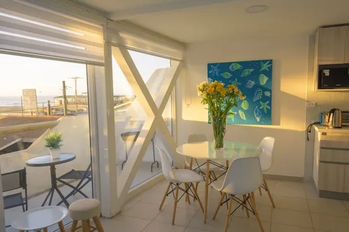 Living comedor del Departamento 3 con ventanal y vista al mar