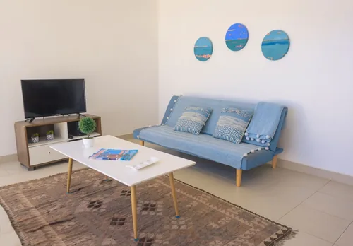 Living del Departamento 4 con sofá cama y televisor